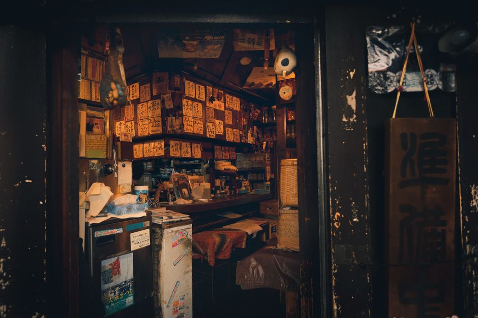 Explore a quaint and cozy traditional Japanese interior with warm lighting and rustic decor in Tokyo.